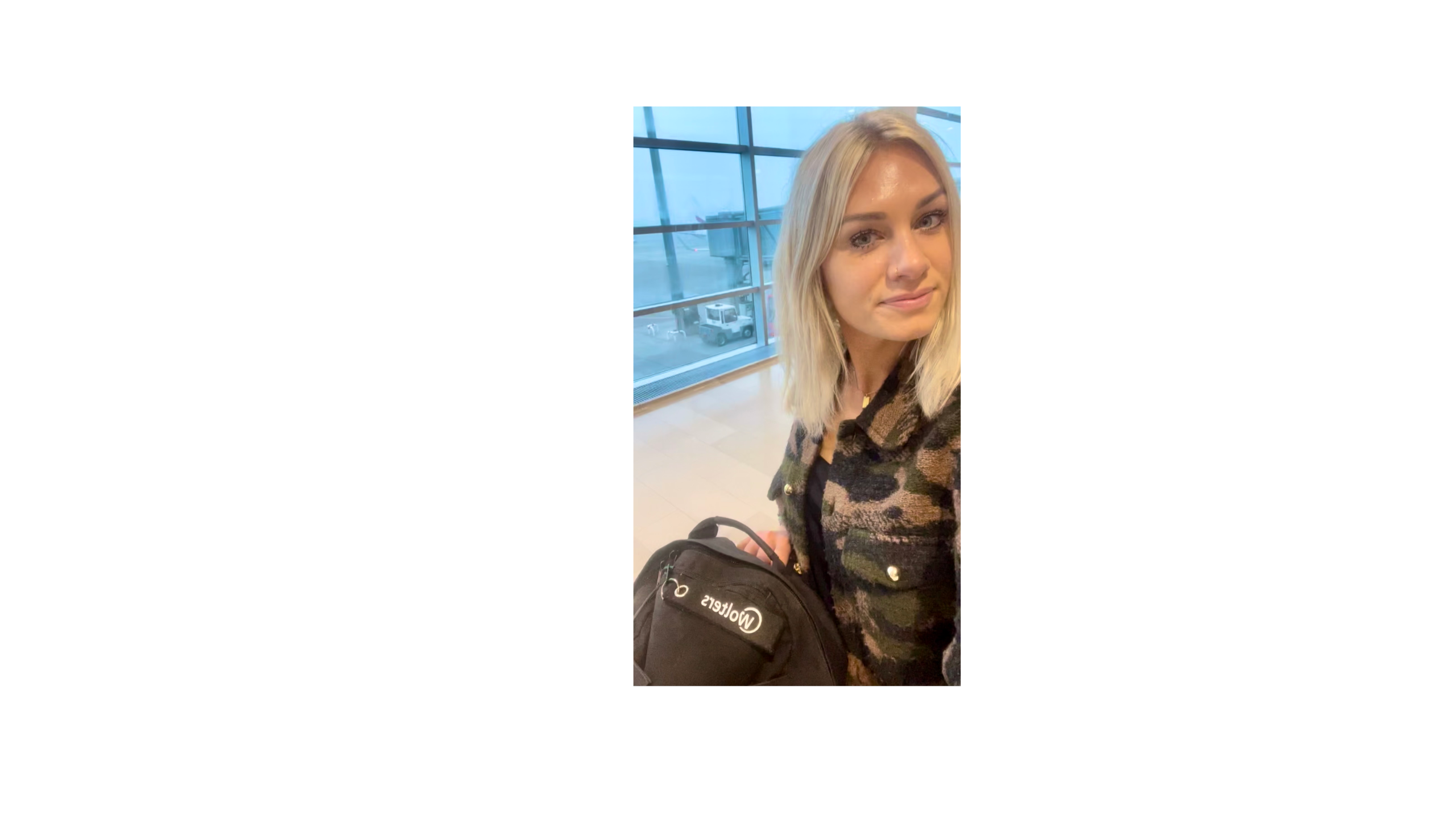Eine Frau macht am Flughafen-Gate ein Selfie und fängt mit ihrem erwartungsvollen Blick die Vorfreude auf den Beginn einer neuen Reise und eines unvergesslichen Urlaubs-Abenteuers ein.