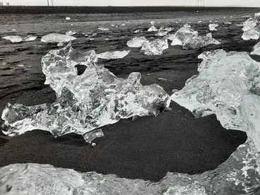 Eisformationen am Diamond Beach auf Island Klare Eisstücke liegen verstreut auf dem schwarzen Lavastrand von Diamond Beach in Island. Das faszinierende Zusammenspiel aus Eis, Meer und dunklem Sand zeigt die einzigartige Naturkulisse des Nordens und macht Island zue